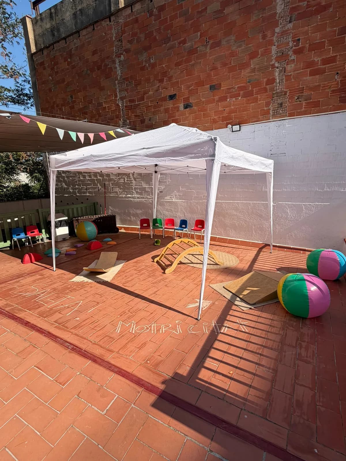 Carpa plegable blanca muntada al pati d'una escola infantil