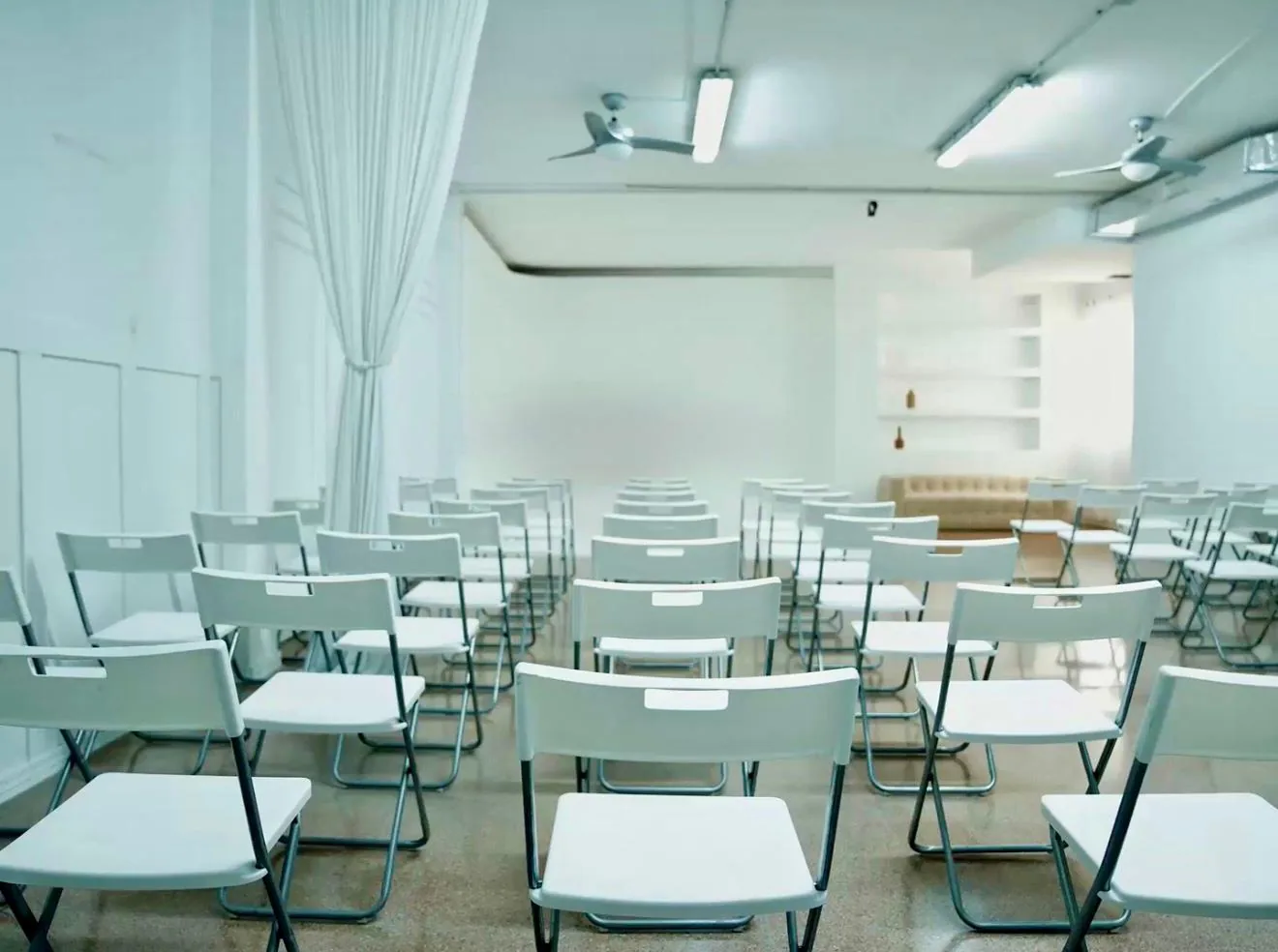 Sala diàfana amb cadires plegables blanques en files